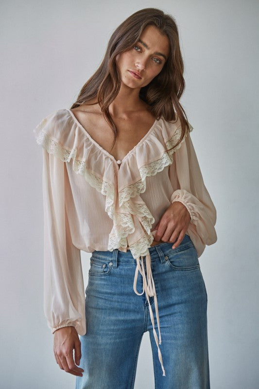 The Blush Ruffle Blouse features romantic ruffle details and a flattering peplum fit in a soft blush pink. The perfect feminine top for brunch, events, or everyday chic styling.