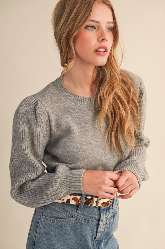 grey ribbed sleeve sweater, women’s ruffle sleeve knit top, statement sleeve sweater, soft grey sweater for women, feminine knitwear, trendy women’s sweaters 2025, ribbed detail sweater, chic grey knit top, cozy fall sweater for women